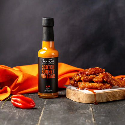 Spicy Ryes Scotch Bonnet vinegar bottle with a colorful label, showcasing the spicy pepper flavor and clear liquid inside.