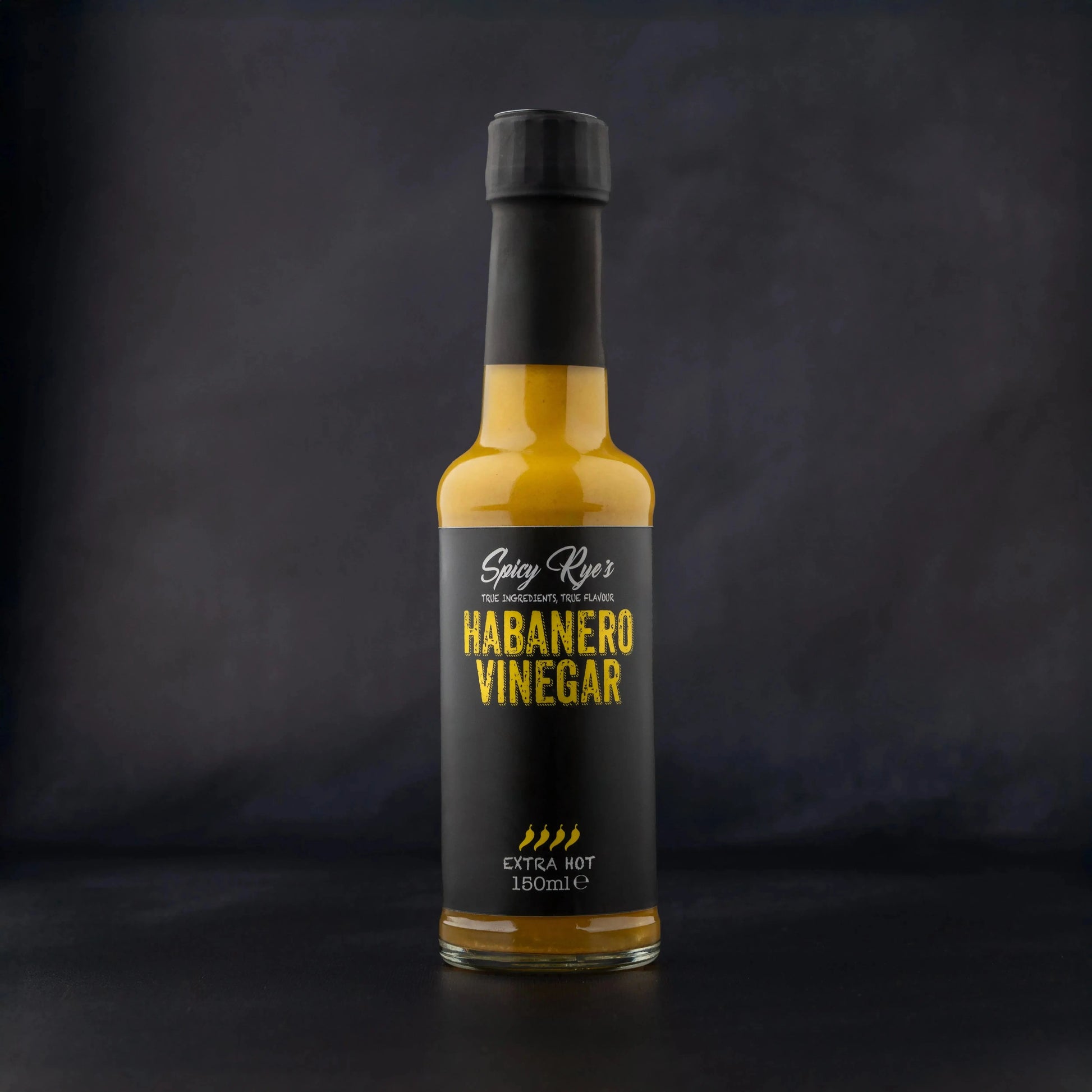 Spicy Ryes habanero vinegar in a glass bottle, showing bright orange habanero peppers and clear vinegar inside.