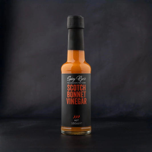 Spicy Ryes Scotch Bonnet Vinegar bottle with label, showcasing bright red chili peppers and bold branding on a white background.