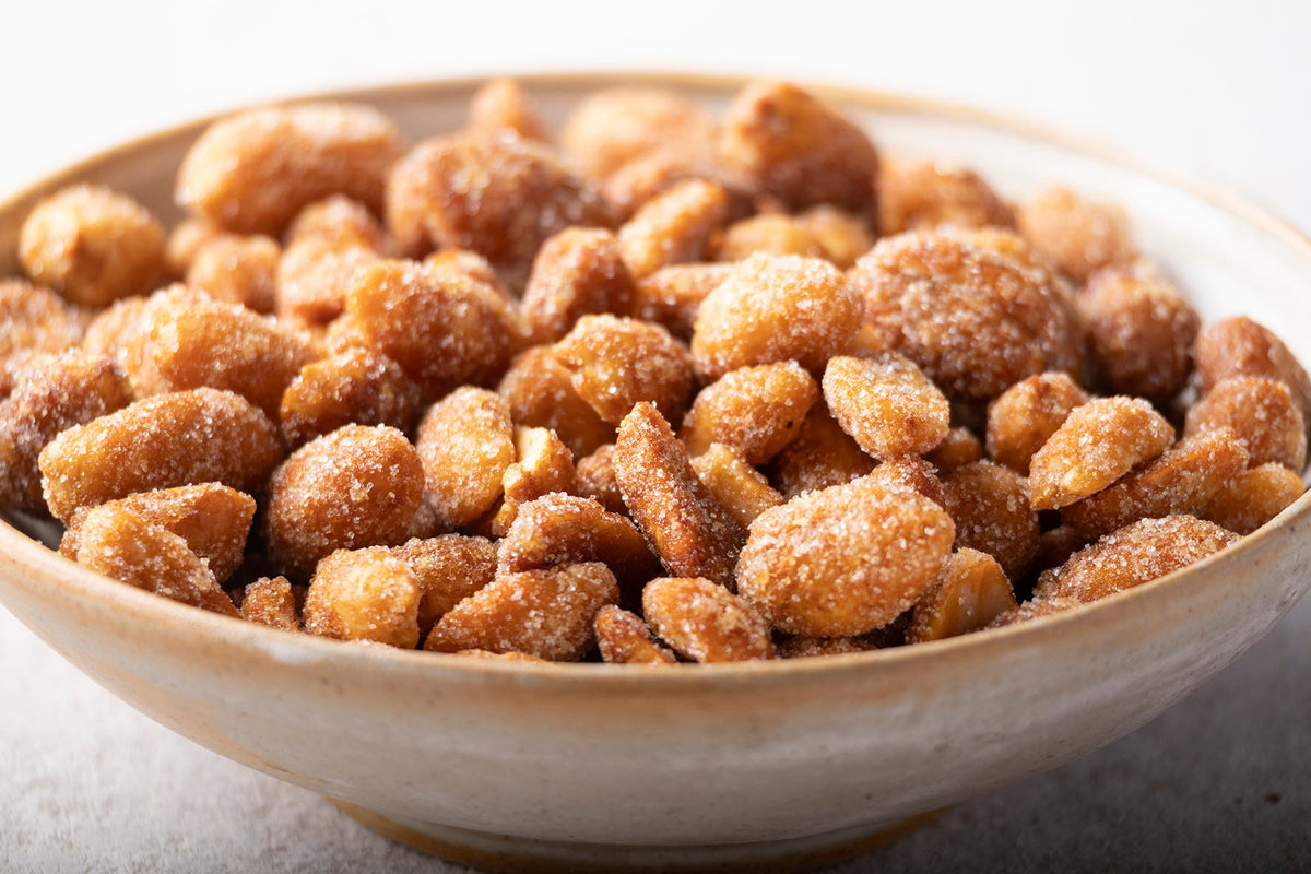 Golden honey roasted peanuts from Whole Food Earth in a bowl, showcasing their shiny, caramelized coating and crunchy texture.