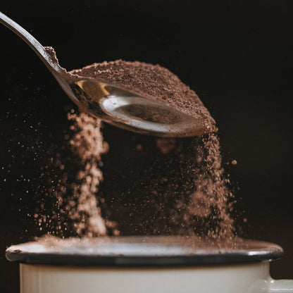 A cup of Harry's Hot Chocolate with a spoon, showcasing rich 60% hot chocolate powder for a comforting beverage.