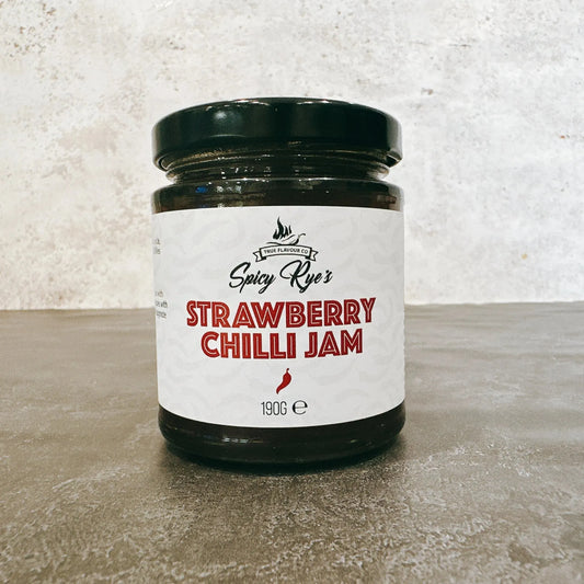 Jar of Spicy Ryes Strawberry Chilli Jam with fresh strawberries and red chili peppers on the label.