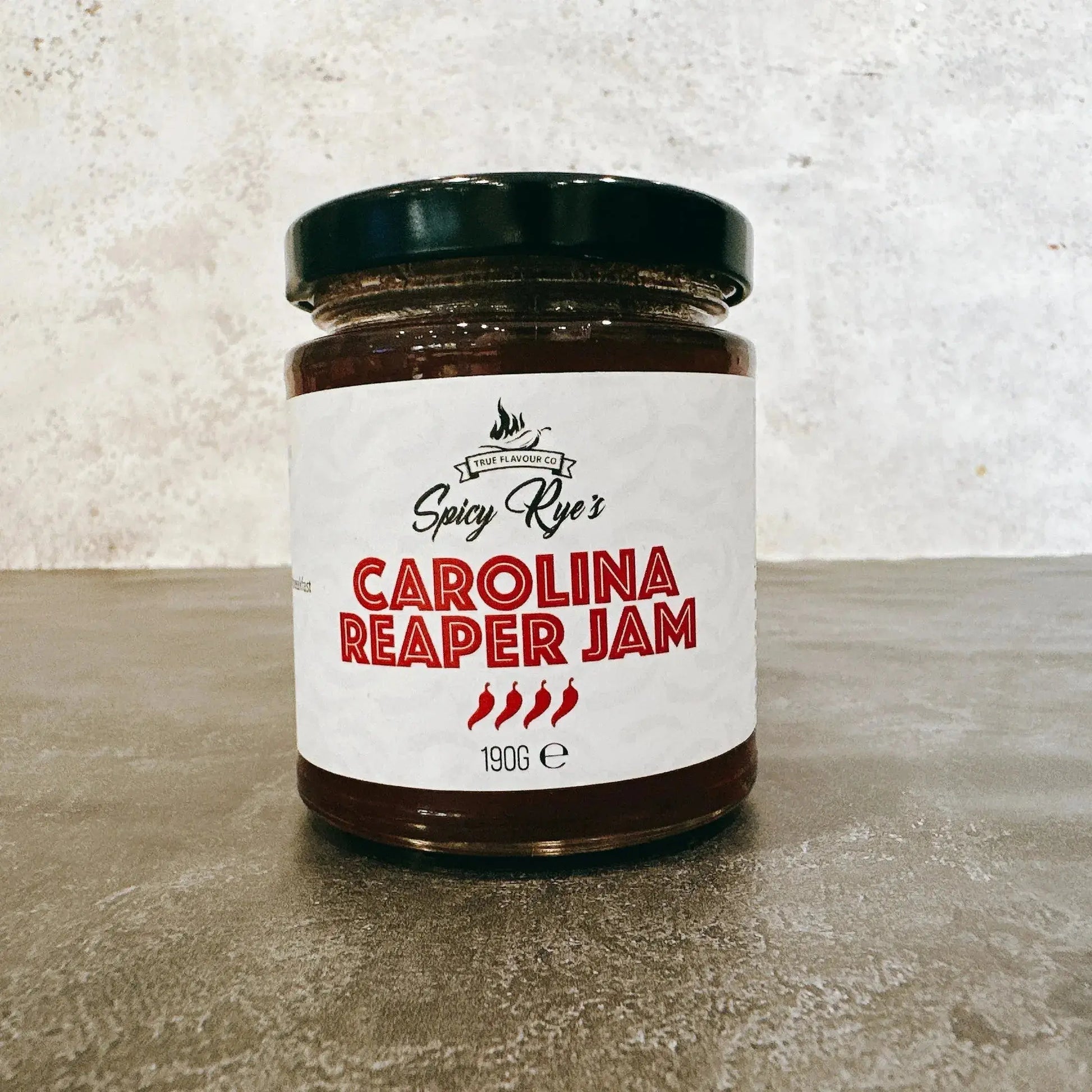 Spicy Ryes Carolina Reaper Chilli Jam jar with vibrant red chili peppers and jam spread on bread slices.