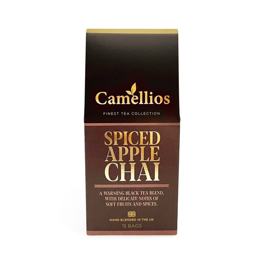 Camellios Spiced Apple Chai tea in a clear glass cup with cinnamon sticks and apple slices, showcasing warm, aromatic infusion.