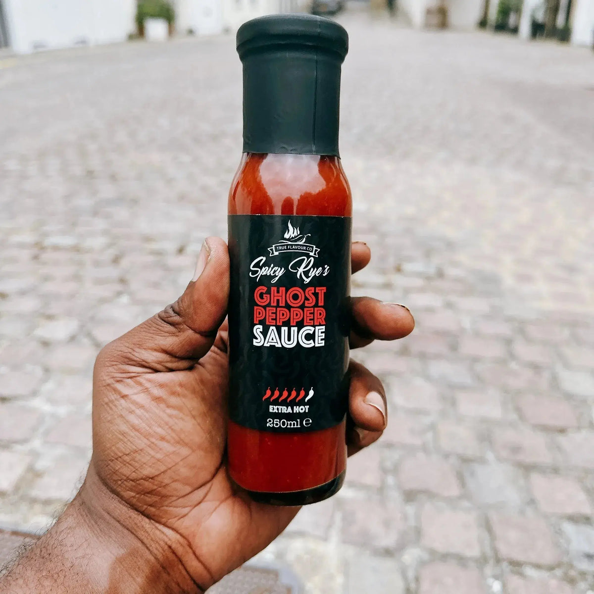 Spicy Ryes Ghost Pepper Hot Sauce bottle with bright label and fiery peppers, showcasing intense chili flavor in a glass bottle.