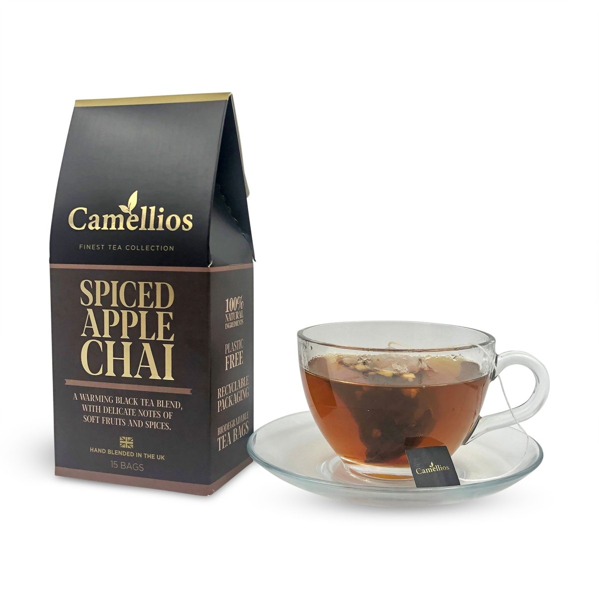 Cup of Camellios Spiced Apple Chai tea in a white mug with cinnamon sticks and apple slices on a wooden table.