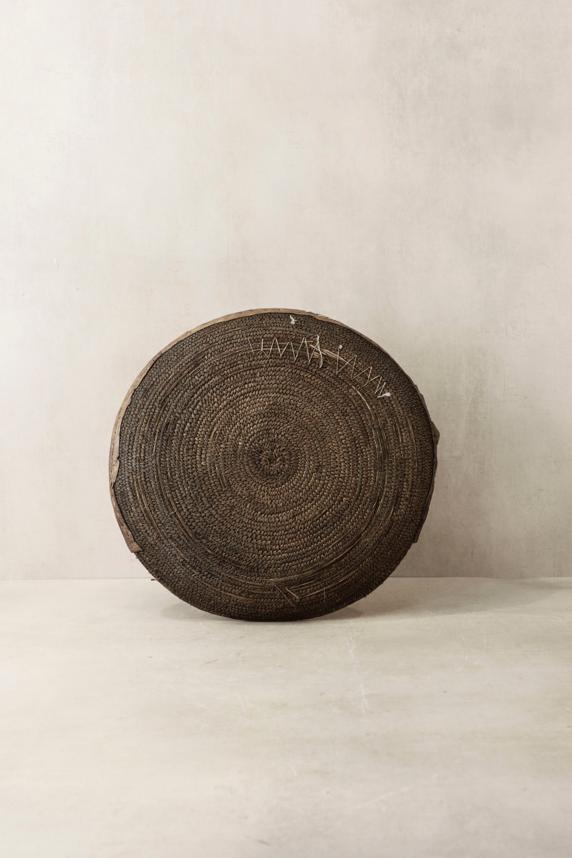 Handwoven wall basket from Chad by Botanical Boys, featuring natural fibers and intricate craftsmanship for decorative wall display.