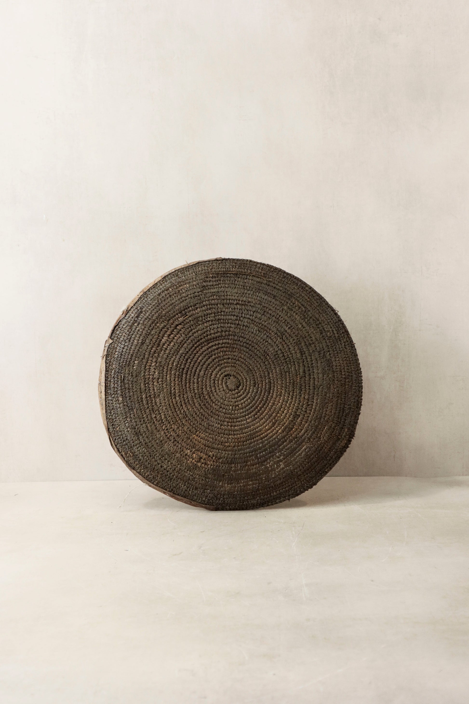 Handwoven wall basket from Chad by Botanical Boys, showcasing intricate craftsmanship and natural fiber textures.