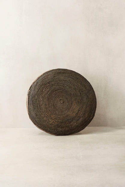 Handwoven wall basket from Chad by Botanical Boys, showcasing intricate craftsmanship and natural fiber textures.