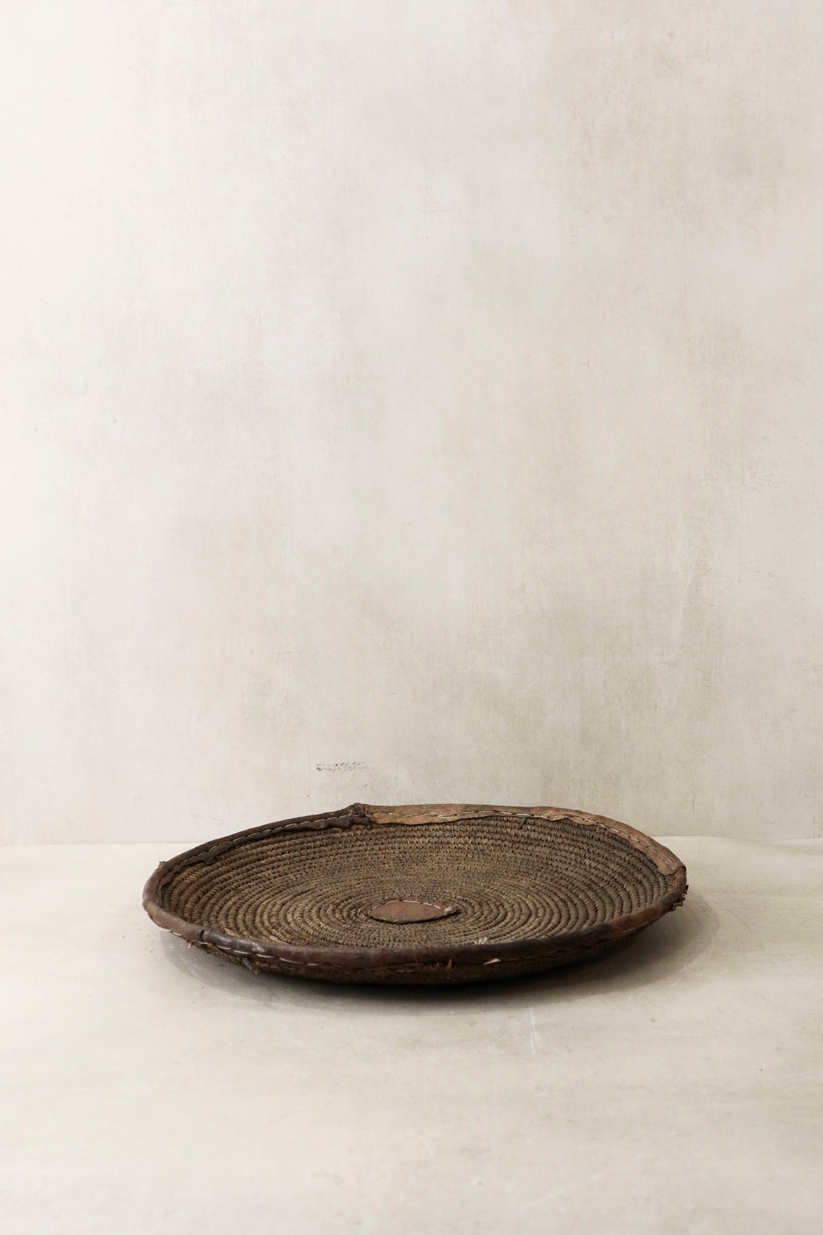 Handwoven wall basket from Chad by Botanical Boys, showcasing intricate natural fiber craftsmanship and wall-mounted design.