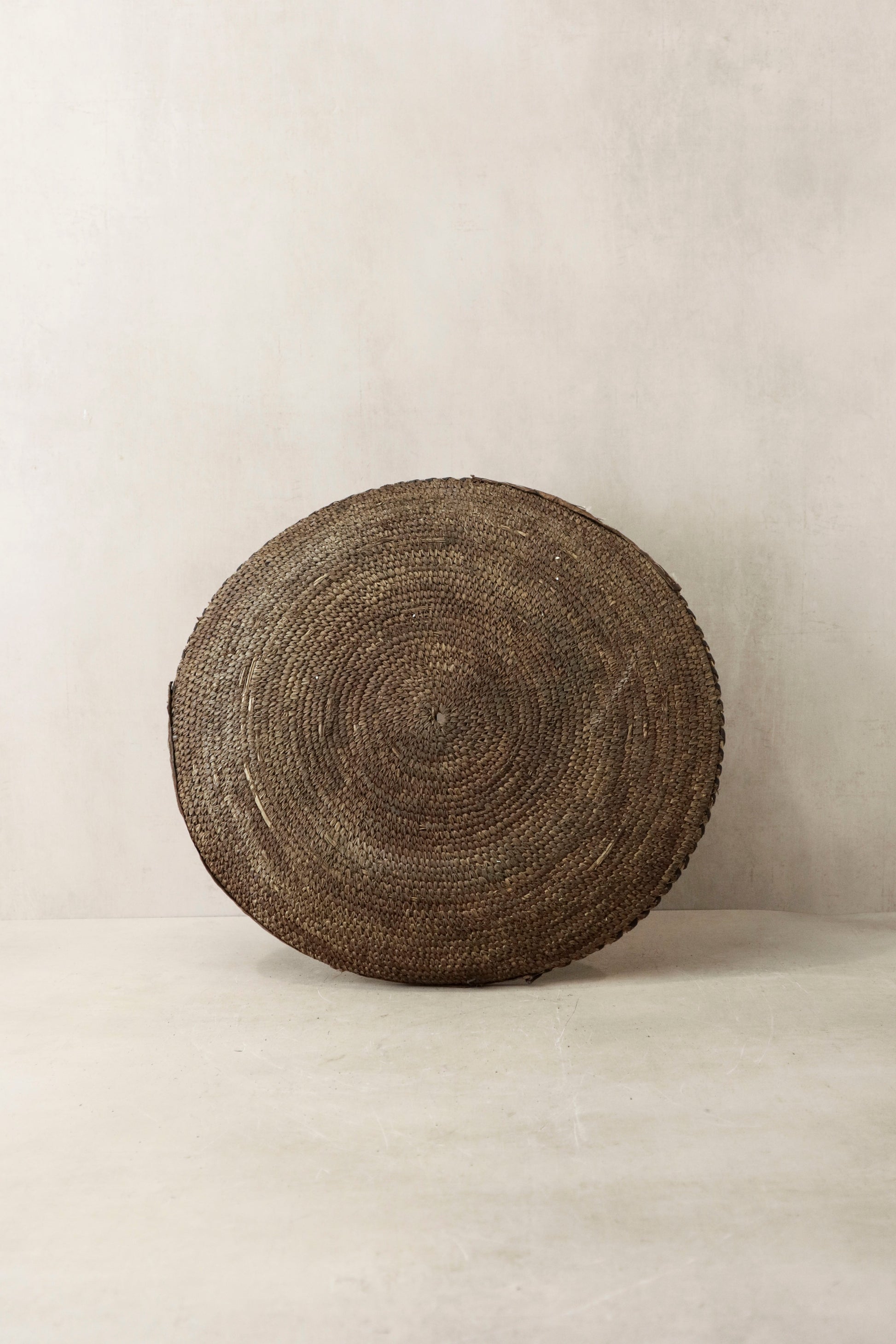 Handwoven Chad wall basket by Botanical Boys, featuring intricate natural fibers and a circular shape for rustic decor.