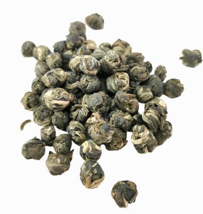 Porter Hill Tea Company Jasmine Dragon Pearls green tea with crafted white pearls and fresh jasmine blossoms in a close-up image.