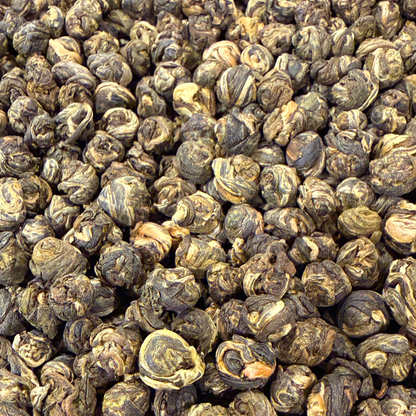 Loose green tea pearls called Jasmine Dragon Pearls by Porter Hill Tea Company, showing delicate green tea leaves with jasmine scent.
