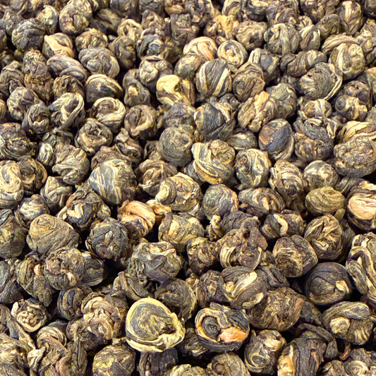 Loose green tea pearls called Jasmine Dragon Pearls by Porter Hill Tea Company, showing delicate green tea leaves with jasmine scent.