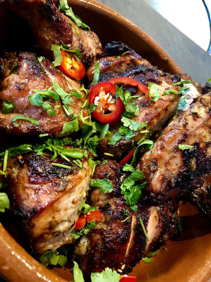 FireFly Barbecue Boston Beach Jerk Rub on seasoned jerk chicken, showcasing vibrant spices and grilling texture.