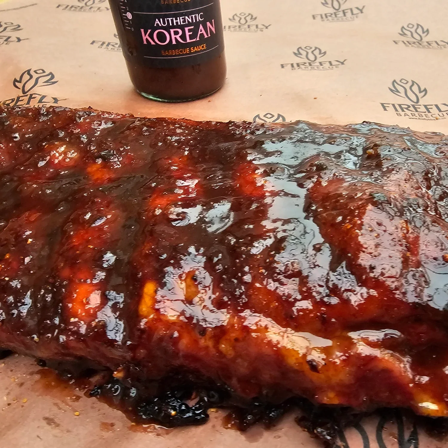 FireFly Barbecue Korean BBQ sauce poured over ribs, showcasing rich, flavorful Korean-style BBQ sauce on tender meat.