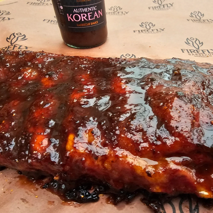 FireFly Barbecue Korean BBQ sauce poured over ribs, showcasing rich, flavorful Korean-style BBQ sauce on tender meat.