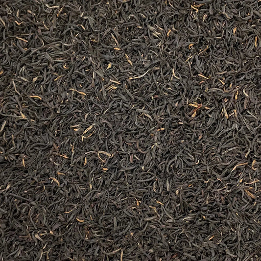 Loose leaf Kenya Kosabei Estate TGFOP tea by High Teas, showing dark amber leaves with golden tips in a close-up view.