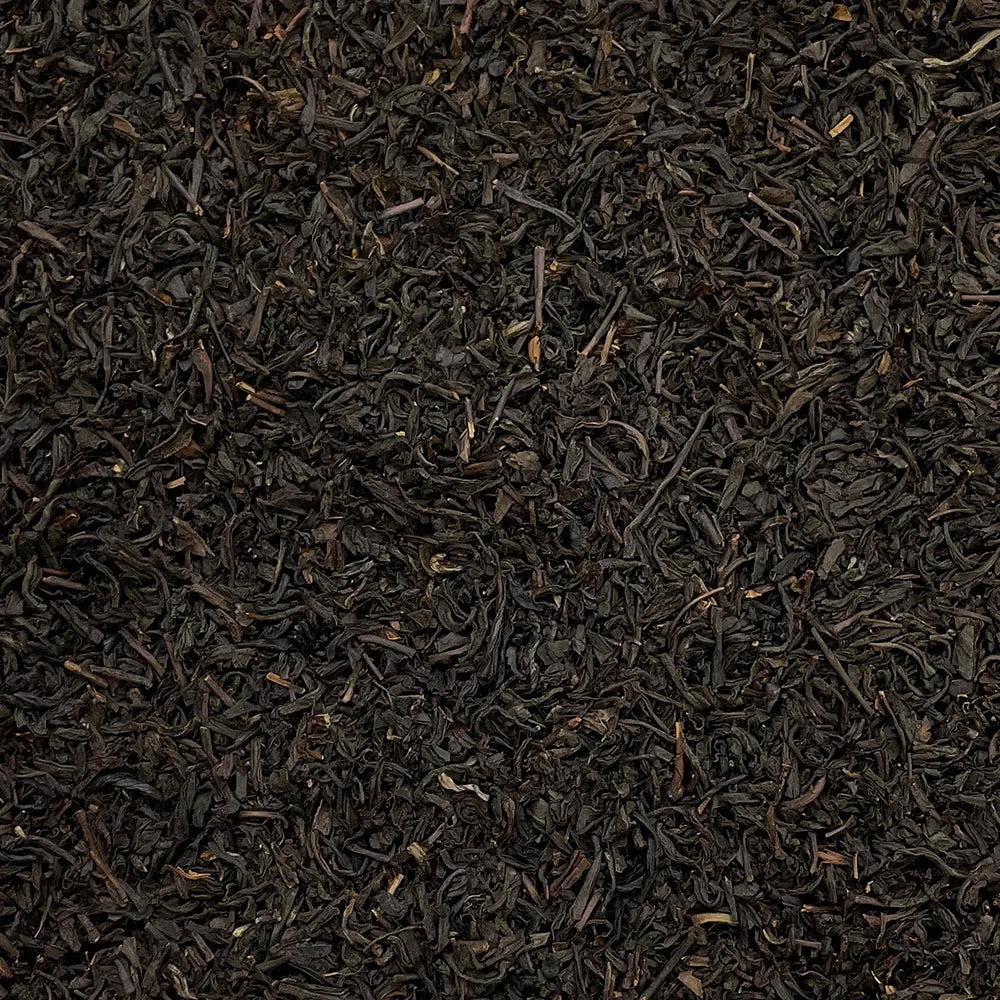 Loose leaf Lapsang Souchong Butterfly tea from High Teas, showing dark, twisted tea leaves in a clear glass jar.