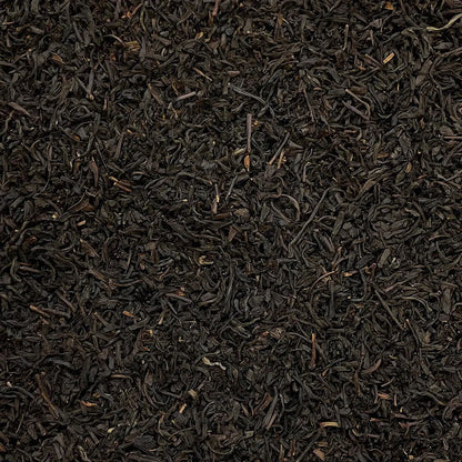 Loose leaf Lapsang Souchong Butterfly tea from High Teas, showing dark, twisted tea leaves in a clear glass jar.