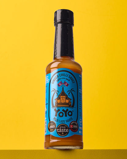 Bottle of YoYo Laos Sauce "MILD" Ginger Chilli Sauce showing the label and sauce inside the transparent bottle.