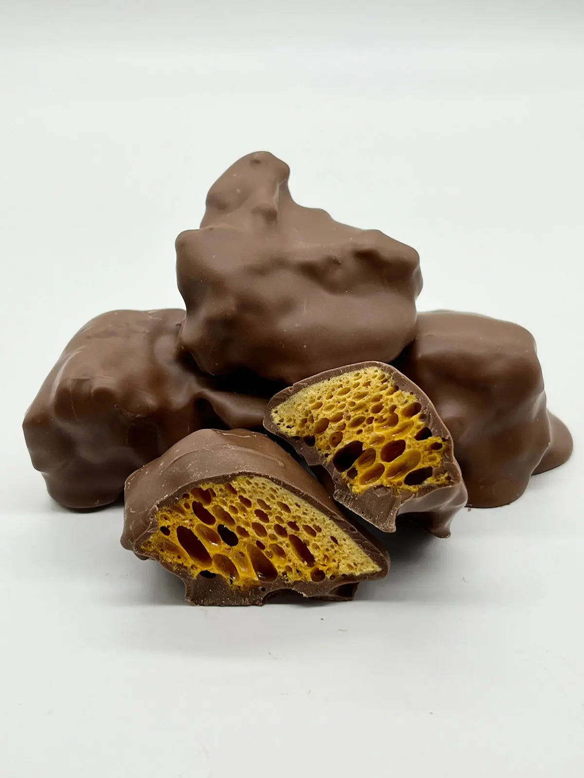 Milk chocolate cinder toffee and honeycomb in a 250g package by Gorvett & Stone, showcasing the crispy toffee coated in smooth milk chocolate.