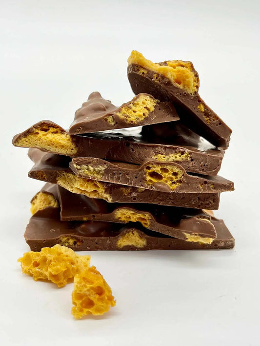 Stack of Gorvett & Stone fine milk chocolate honeycomb shards, showcasing the crunchy honeycomb pieces coated in smooth milk chocolate.
