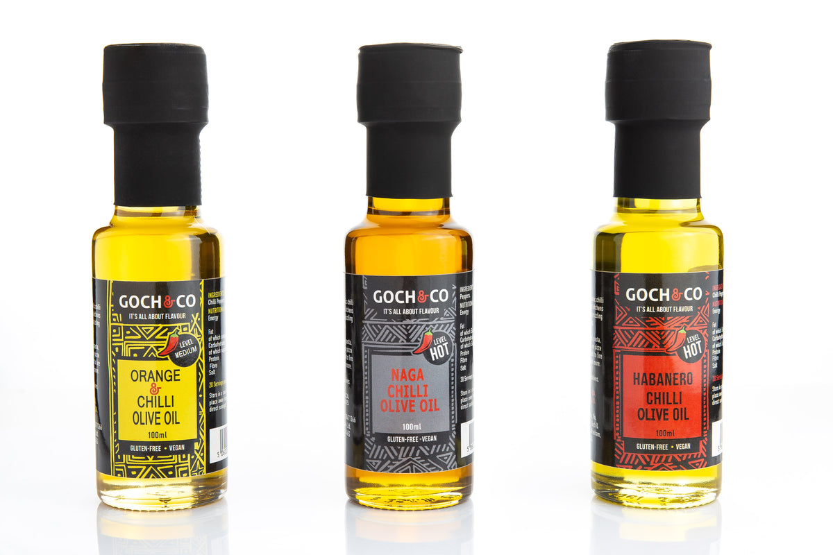 Goch & Co Naga Chilli Olive Oil bottle with label, showcasing the spicy chili-infused olive oil product on a wooden surface.