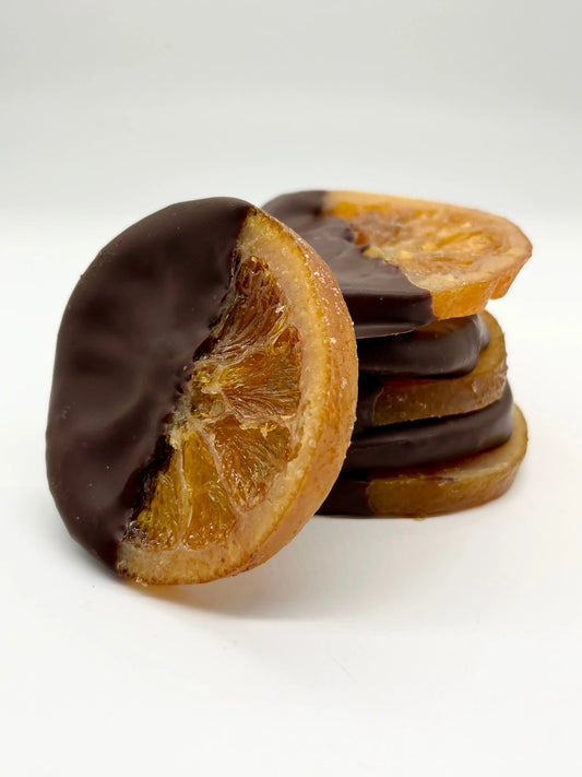 Fresh orange slices from Gorvett & Stone arranged on a white plate, showcasing bright, juicy citrus segments.