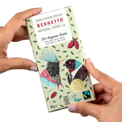 Bennetto Natural Foods UK organic dark chocolate bar, 70% cocoa, with hands holding the chocolate piece.