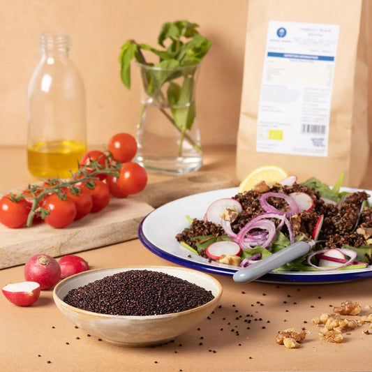 Organic black quinoa from Serious Grains displayed in a lifestyle setting with bowls and fresh ingredients.