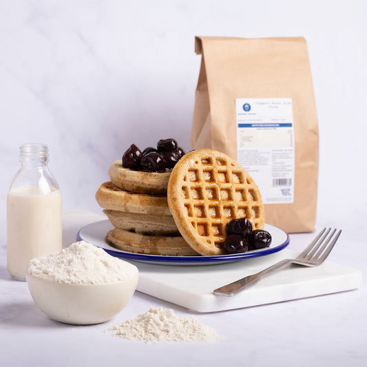 Organic brown rice flour from Serious Grains in a natural kitchen setting, showcasing a bowl of flour and related baking ingredients.