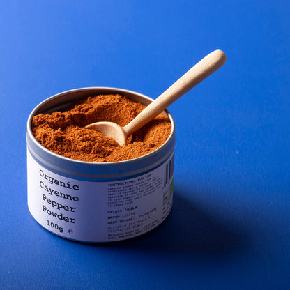 Organic cayenne pepper powder from Wild Elephant, a vibrant red spice in a clear jar, used for adding heat and flavor to dishes.