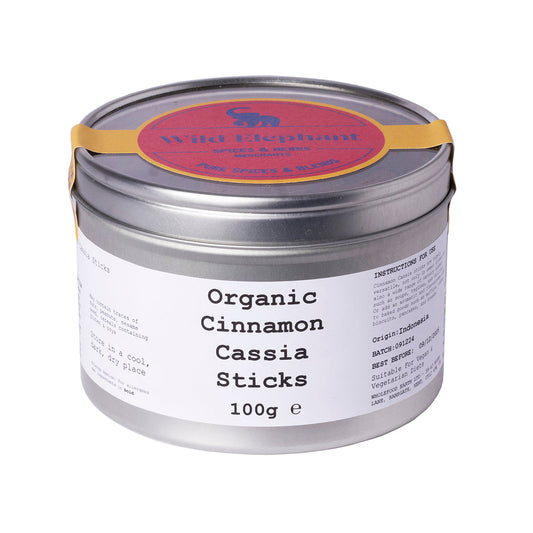 Organic cinnamon cassia sticks from Wild Elephant, 100g, showing brown, aromatic cinnamon sticks on a rustic surface.