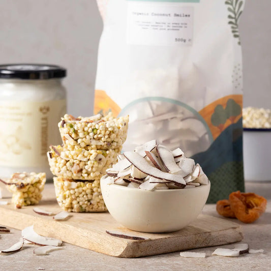 Organic Coconut Smiles by ArtisanBox showing close-up of coconut-flavored snacks on a rustic wooden surface.