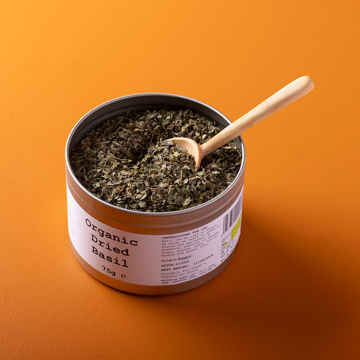 Organic dried basil from Whole Food Earth, wild-harvested herbs in a 75g package, shown in a clear close-up image.