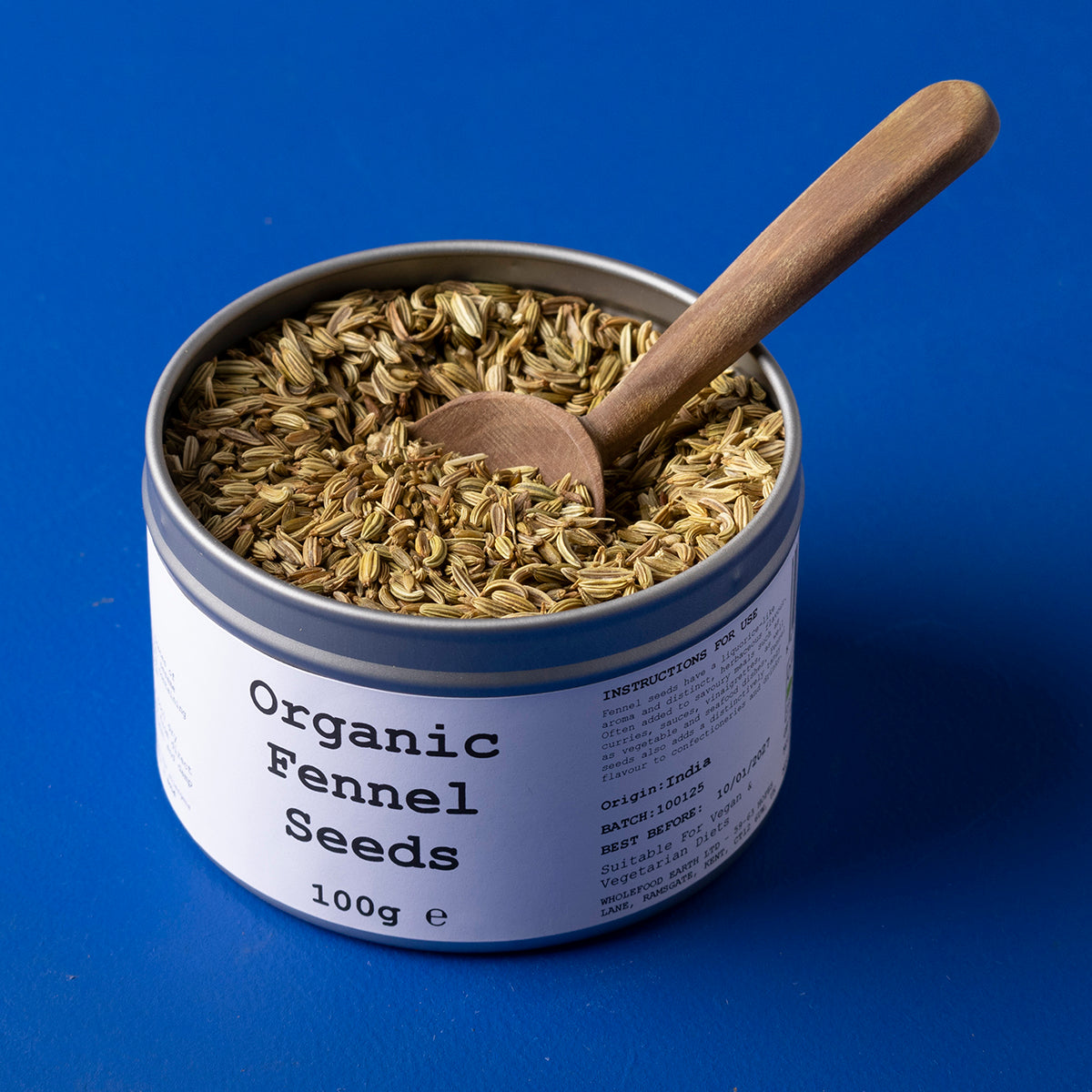 Organic fennel seeds from Wild Elephant, 100g, showing fresh greenish seeds in a clear glass jar on a white background.