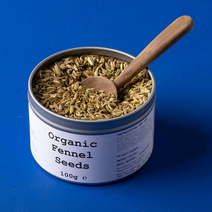 Organic fennel seeds from Wild Elephant, 100g, showing fresh greenish seeds in a clear glass jar on a white background.