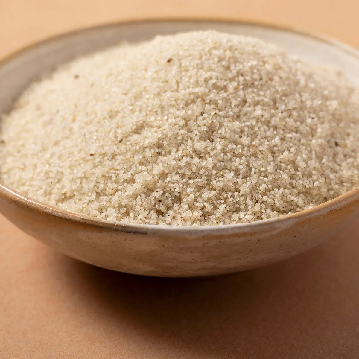 Organic Fonio grains from Whole Food Earth, close-up of small, light-colored cereal grains on a white background.