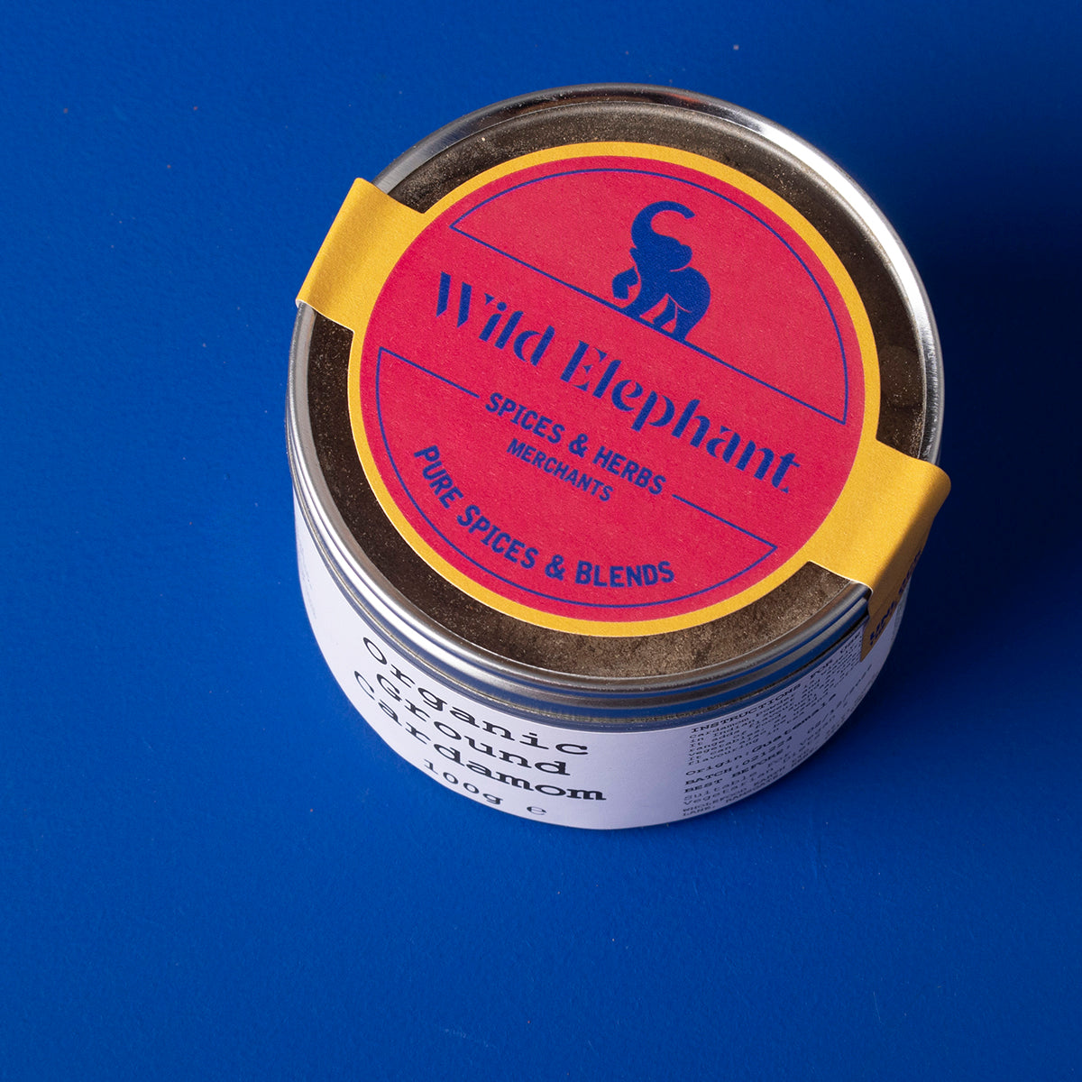 Organic ground cardamom spice from Wild Elephant, 100g, shown in a clear container with fresh green cardamom seeds.