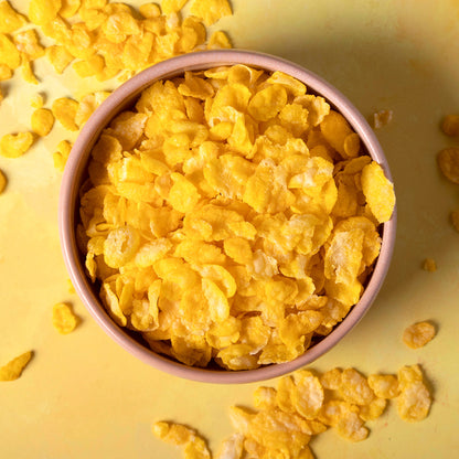 Organic natural corn flakes cereal from Whole Food Earth, showing a bowl of golden corn flakes on a wooden table.
