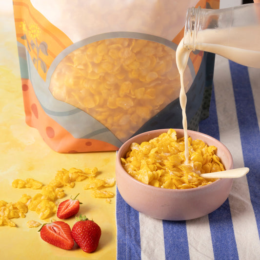 Organic natural corn flakes cereal from Whole Food Earth served in a bowl with milk and fresh fruit.