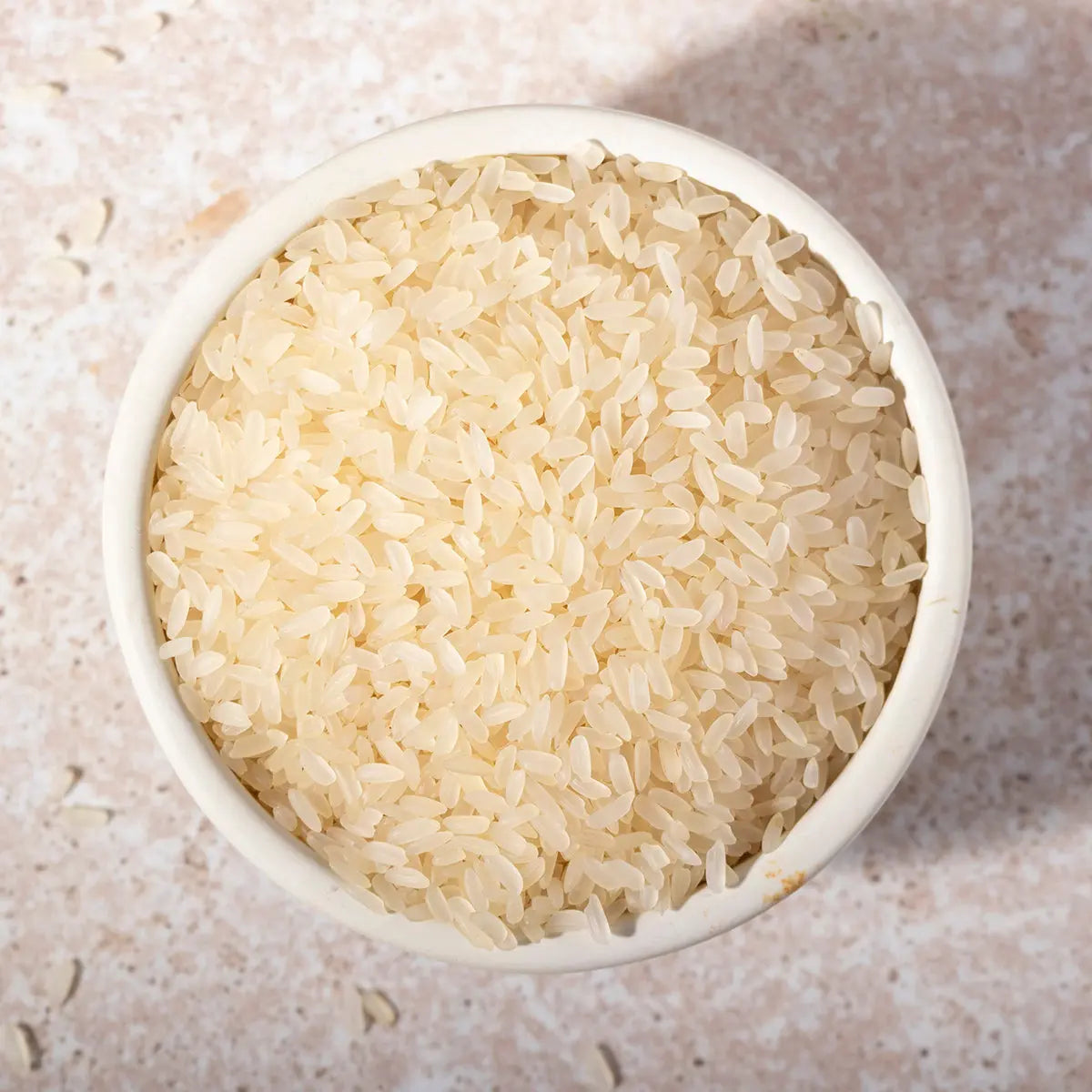Organic parboiled long white rice from Whole Food Earth, showing a bowl of cooked rice and rice grains on a white background.