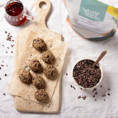 Organic roasted cocoa nibs from Whole Food Earth, shown in a baking setting with cocoa nibs and ingredients on a wooden surface.
