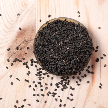 Black organic sesame seeds from Whole Food Earth, small nut-like seeds for cooking and baking in a clear container.