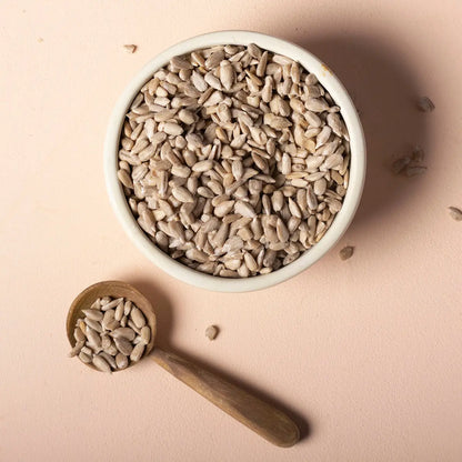 Whole Food Earth organic sunflower seeds, raw and unsalted, shown in a clear container on a white background.