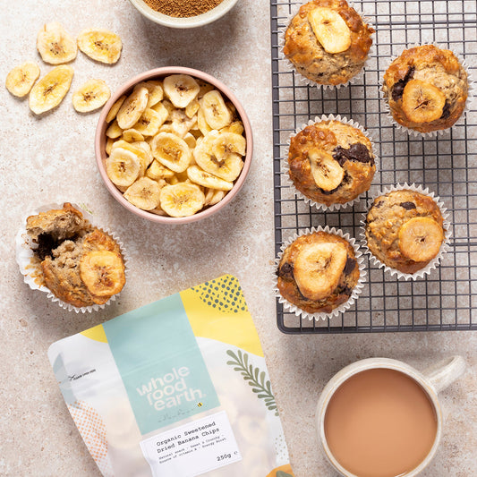 Organic sweetened dried banana chips from Whole Food Earth, showing golden banana slices on a rustic wooden surface.