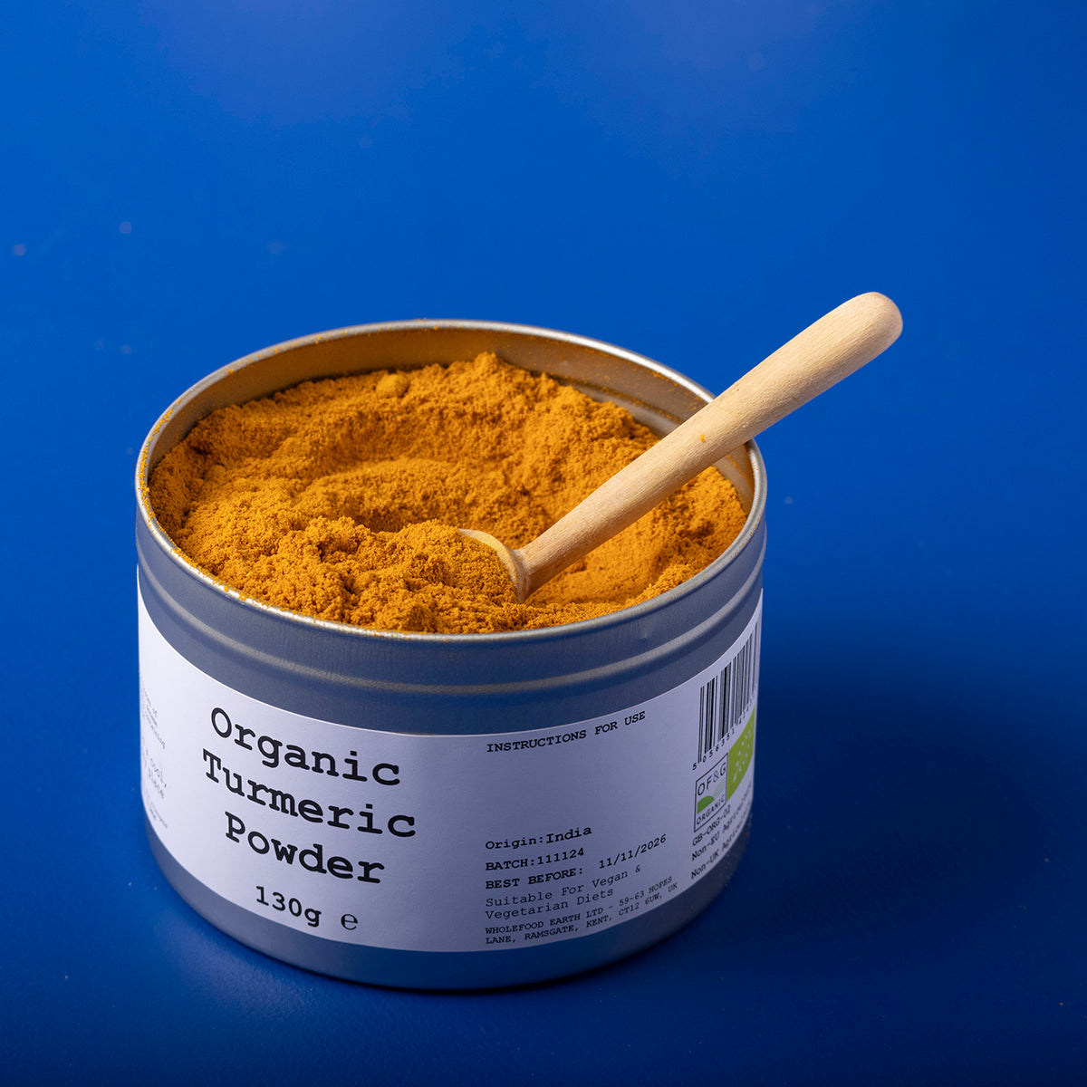 Organic turmeric powder in a clear container, labeled with Wild Elephant brand, showing bright yellow spice from Whole Food Earth.