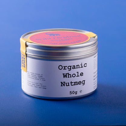 Organic whole nutmeg from Wild Elephant, displayed in a clear container, showcasing the brown, textured spice on a white background.