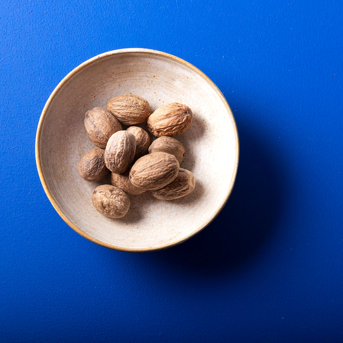 Whole Food Earth organic whole nutmeg from Wild Elephant, 80g, showing fresh whole nutmeg seeds in a natural setting.